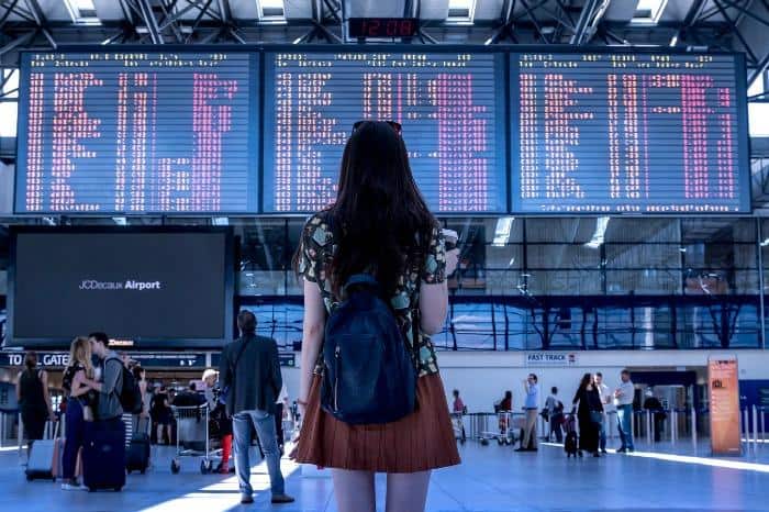 girl looking at airport departures list 