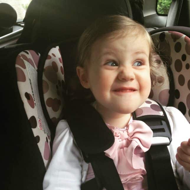 toddler pulling funny face in carseat