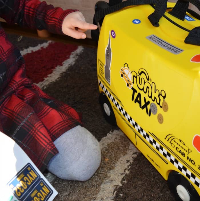 child playing with trunki suitcase