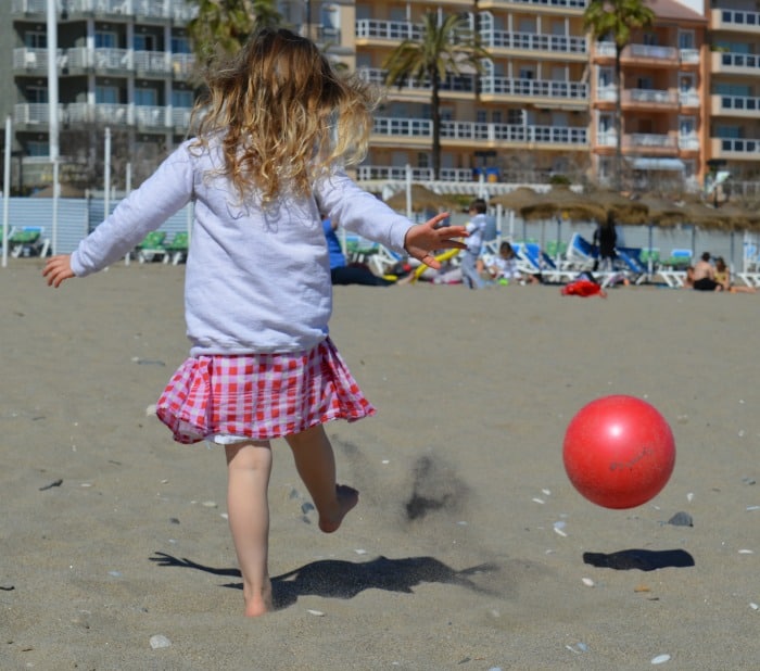 child playing ball on the beach