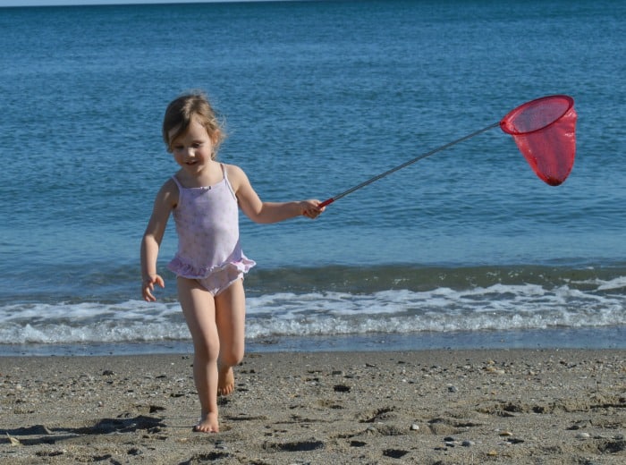 child playing with scrunch net on beach