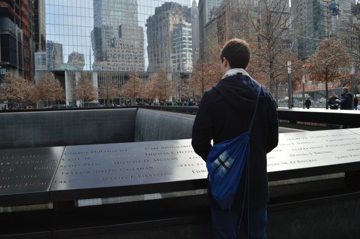 teen Looking at cascading fountains 9/11 Memorial site New York City 