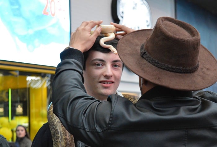 teen wearing a snake on his head