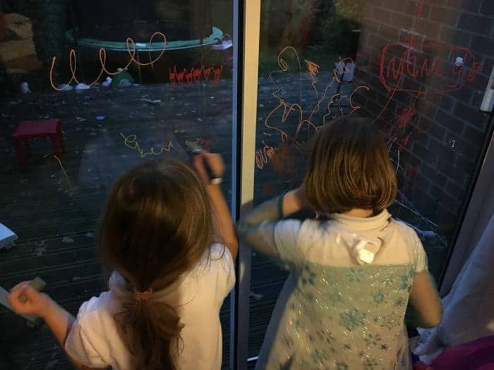 kids-playing-with-chalk-pens-on-patio