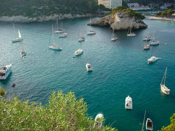 Cala Galdana Beach  with a number of sailing boats anchored off the shore 
