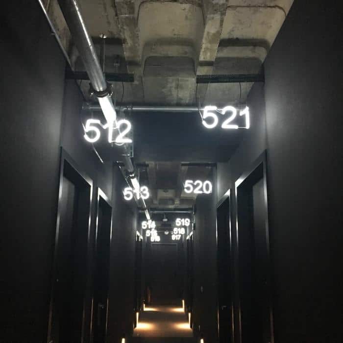 neon numbers and Black hotel corridor with industrial feel inside 25 hours hotel berlin