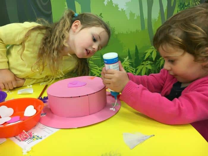 girls making easter bonnets at arts and crafts session