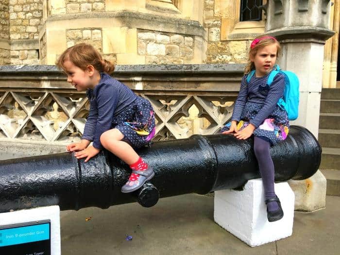 2 girls sitting on a cannon Tower of London