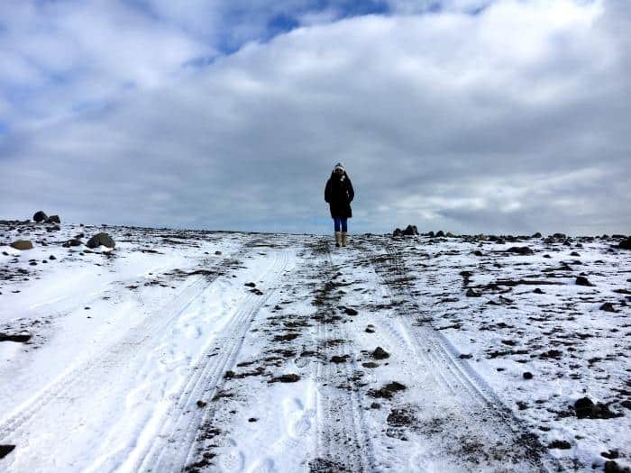Person standing on a snowy hill iceland
