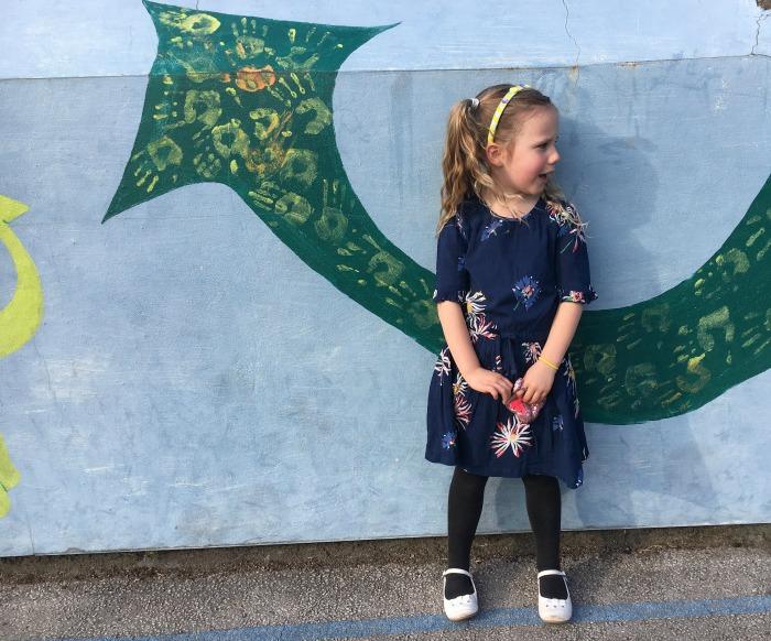 child stood by painted wall