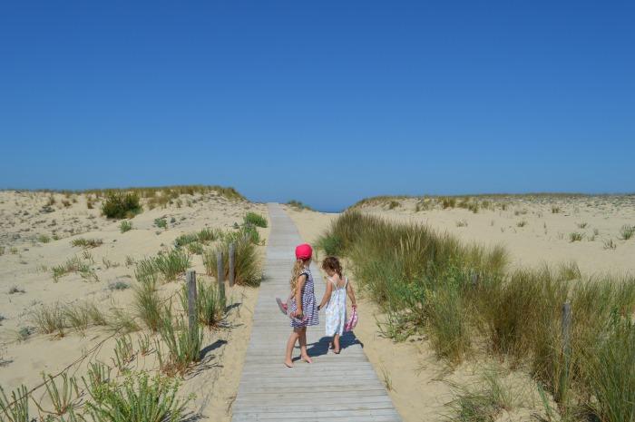 children walking over dunes at lacanau ocean beach 