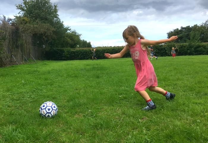 girl kicking football