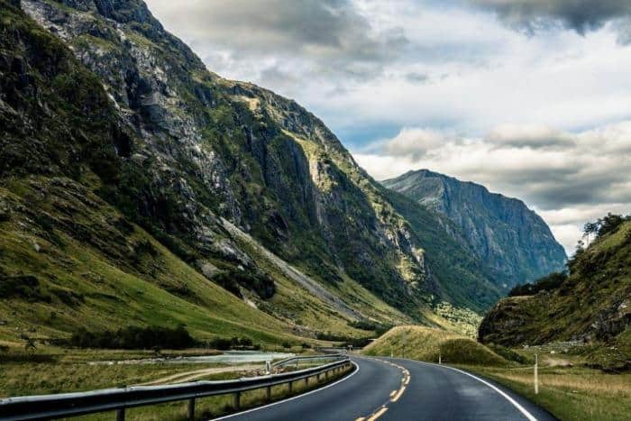 A road winding it’s way through a deep long valley and the Norwegian wilderness