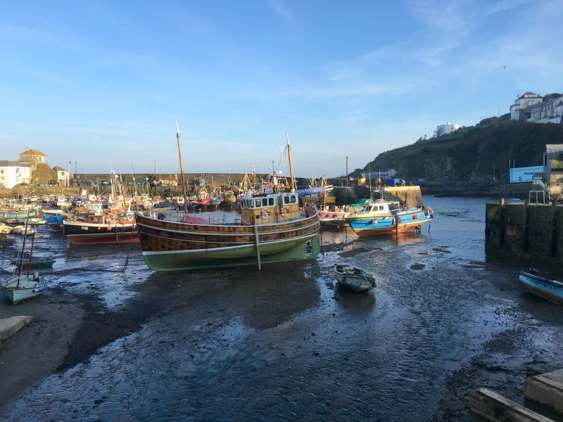 boats in Megavissey harbour Cornwall while tide is out