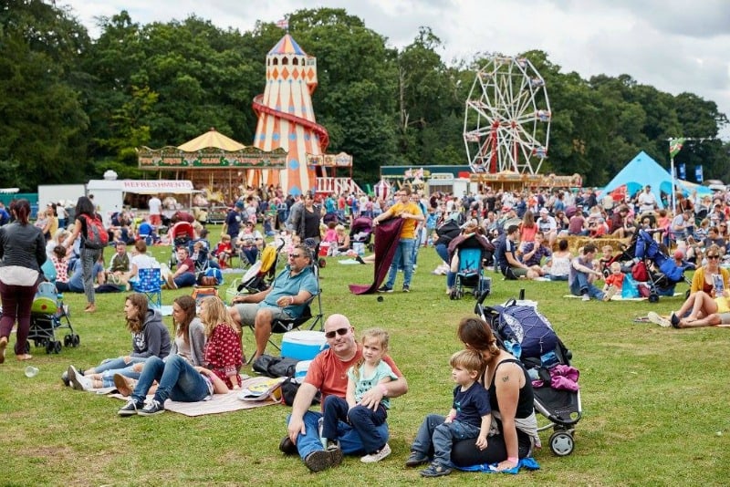 Families sat on field at family friendly festival - Gloworm