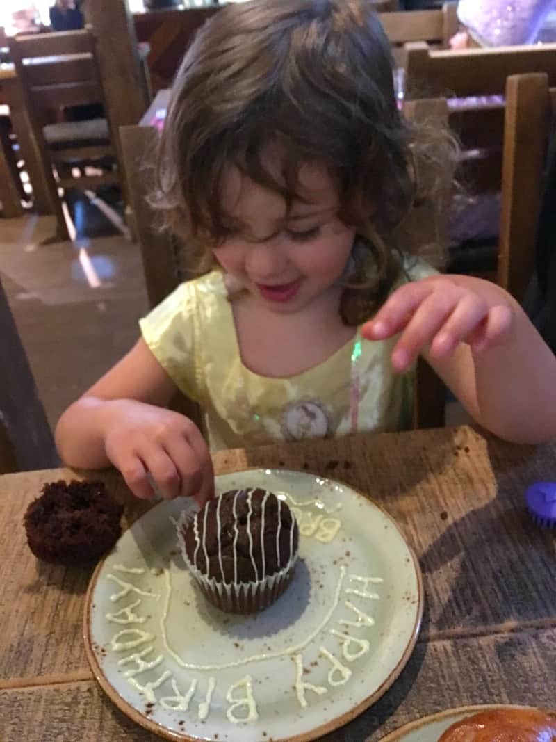 girl dressed as princess eating birthday muffin at warwick castle glamping 
