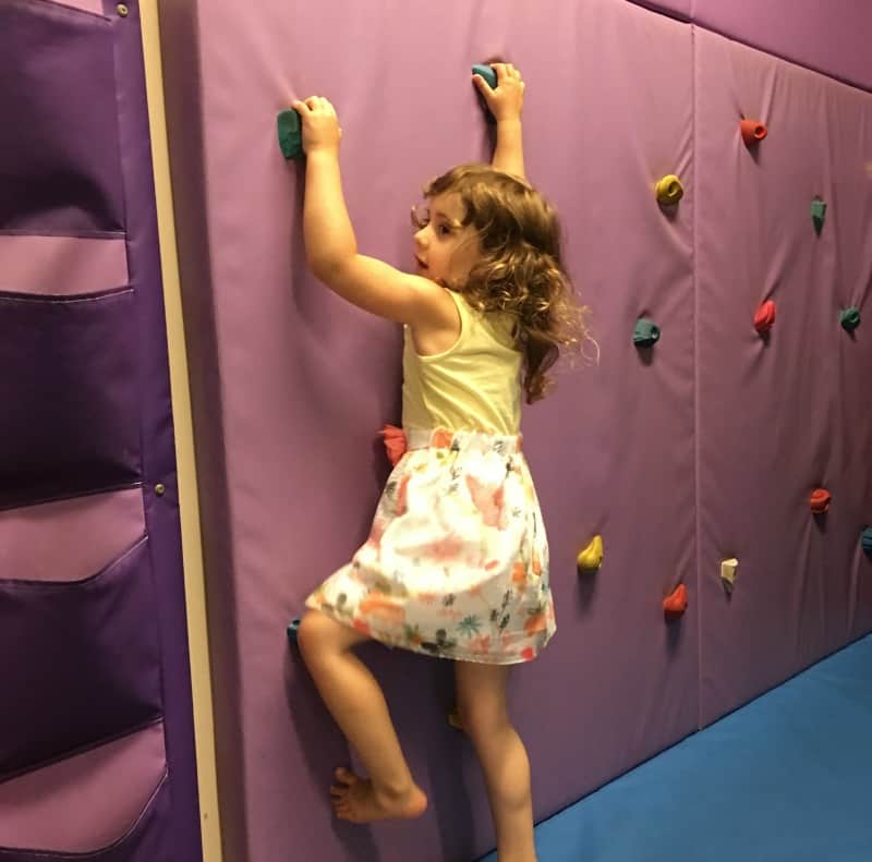 child climbing on wall at soft play in cofton holidays devon