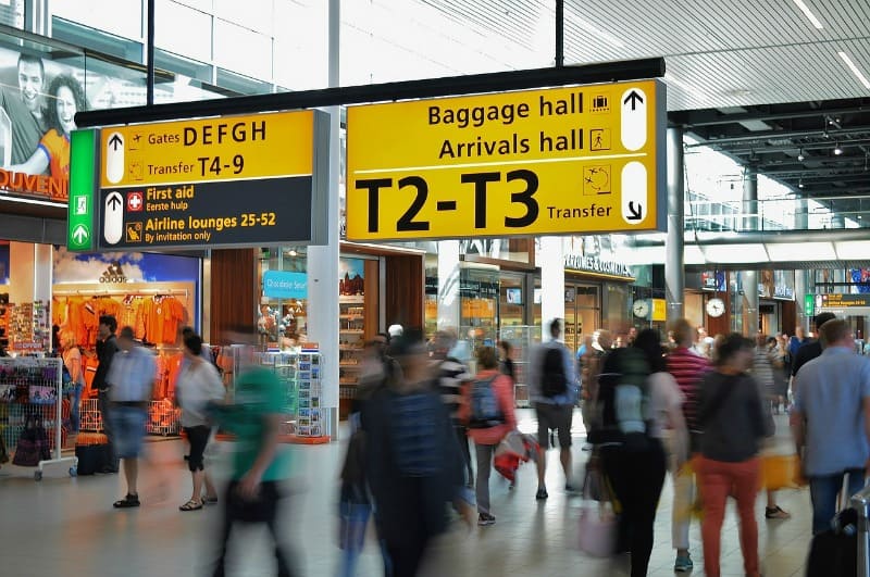 busy airport terminal with signs to baggage and arrivals hall 
