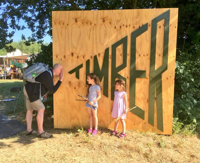 Dad & 2 girls stood at Timber festival sign 