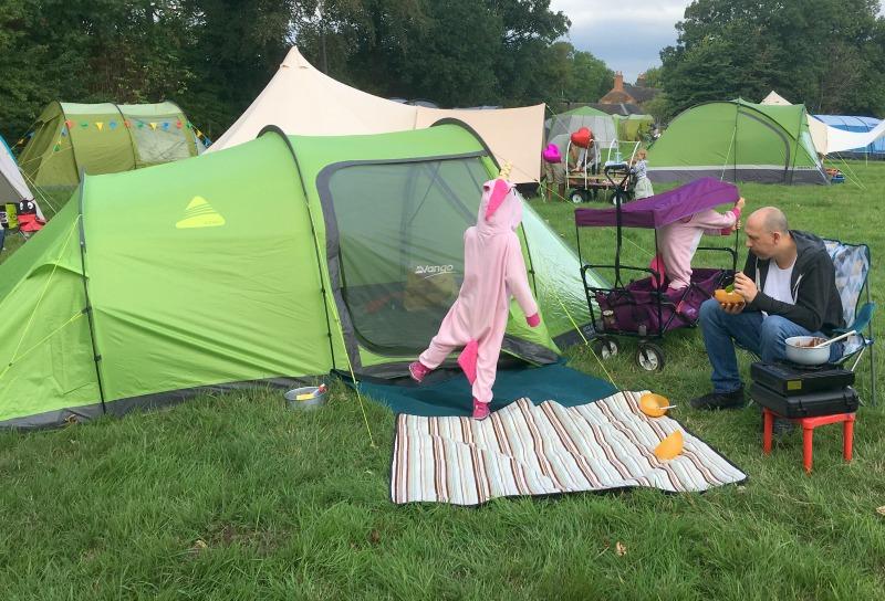 2 children dressed in unicorn onsies with Dad camping with vango 450xl tent