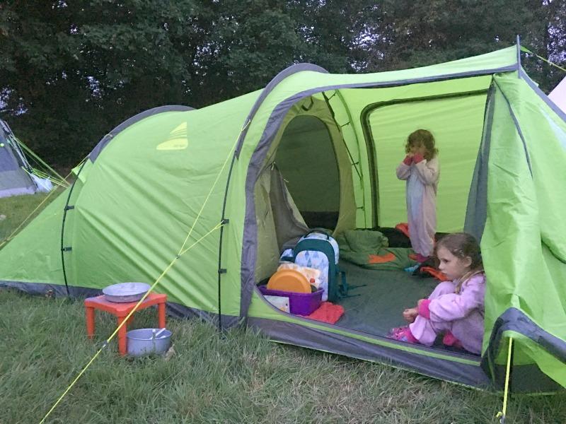 green vango beta 450xl tent with front door open to see inside and bedroom door with kids and camping gear 