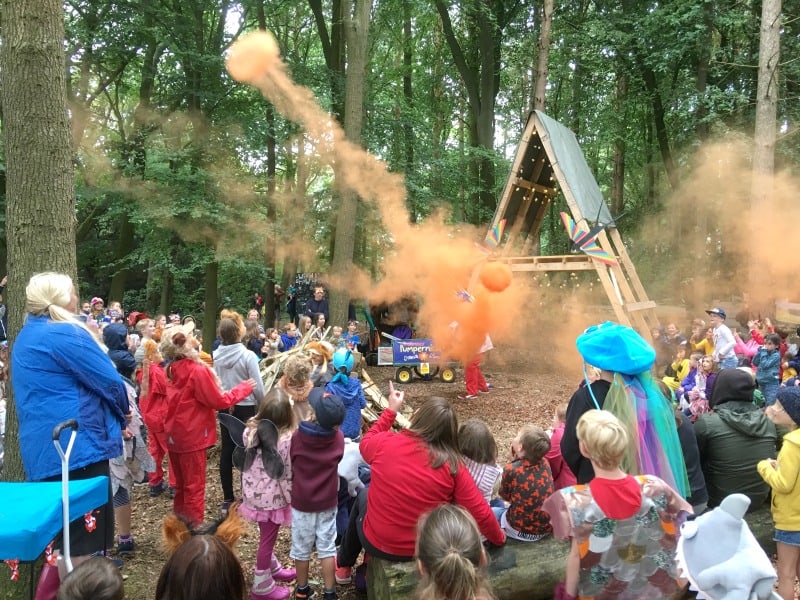 parents and children watching a show in the woods at Just So Festival for families 