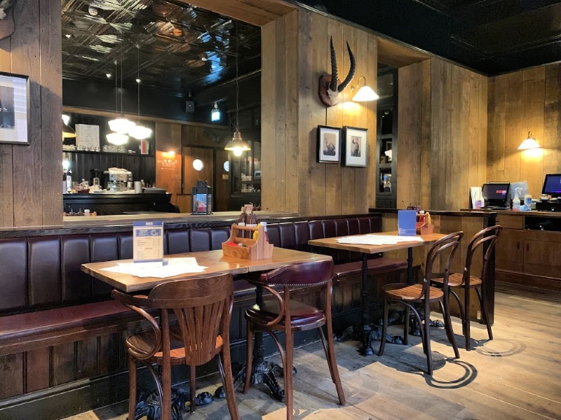 Inside Red Dog Saloon with wood panel walls leather sofas and oak tables and chairs 