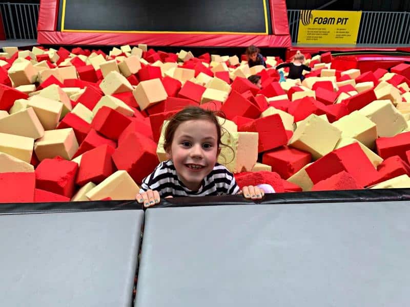 child climbing out of foam pit at trampoline park