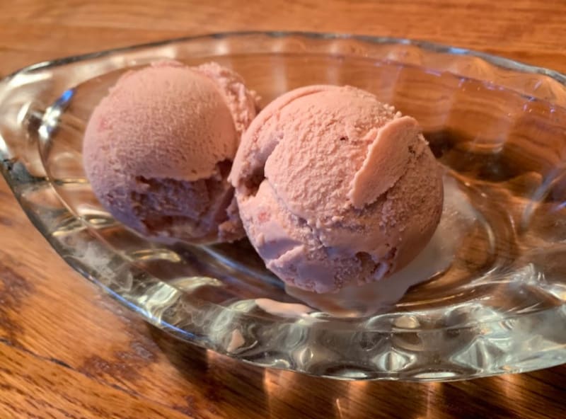 two scoops of strawberry ice cream served in glass dish 