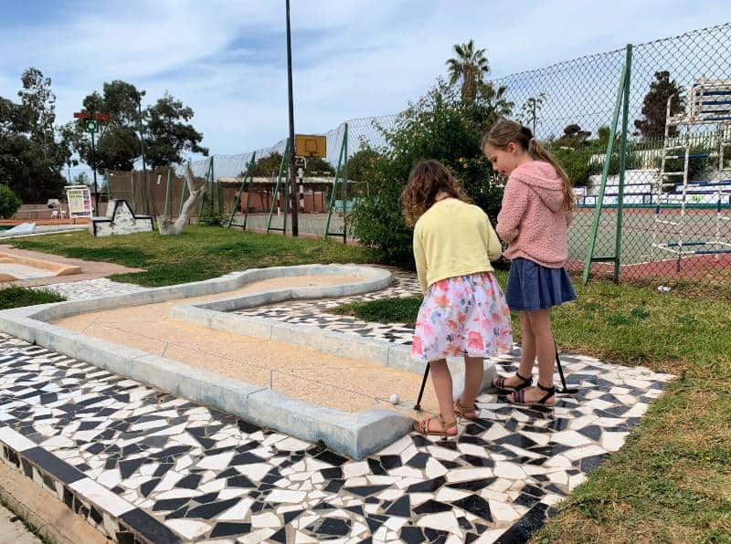 two children playing mini golf