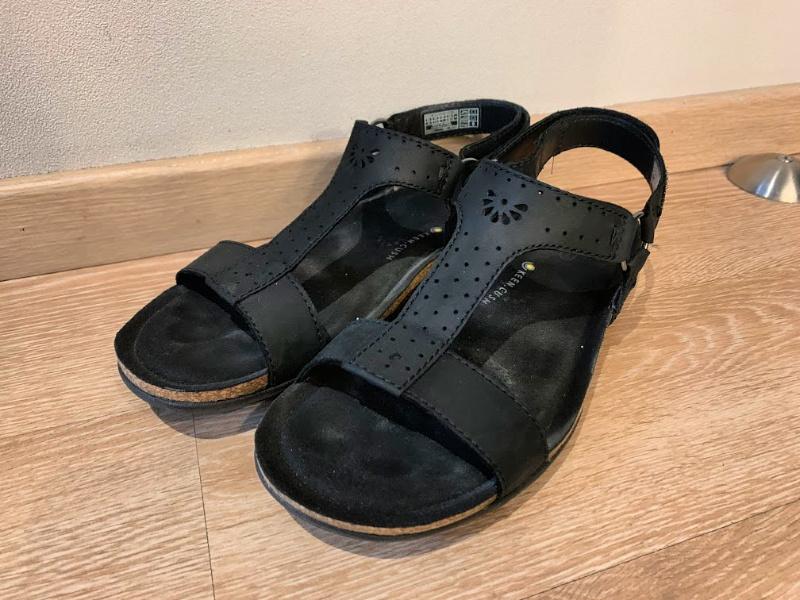 pair of Keen black walking sandals on wooden floor 