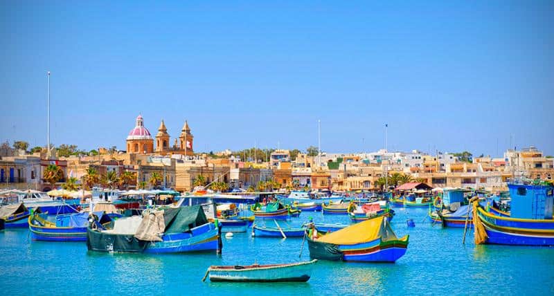 colourful boats in sea with view of Malta 