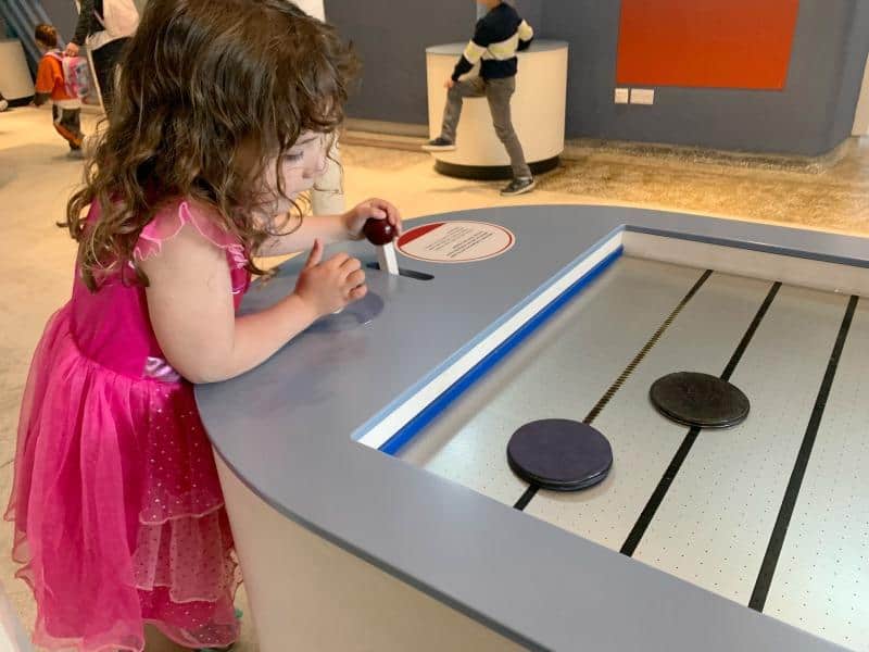 child playing with air hockey style game at esplora science centre