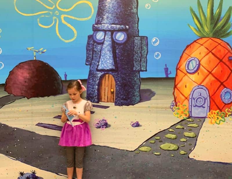 child stood in front of scene from sponge bob square pants show at nickelodeon exhibition 