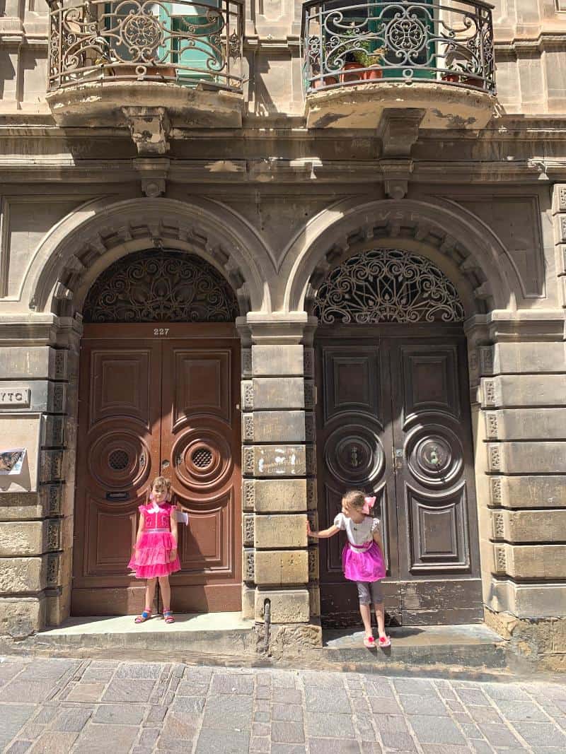 children stood in doorways in Valletta Malta wearing pink
