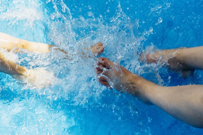 children's feet splashing in paddling pool