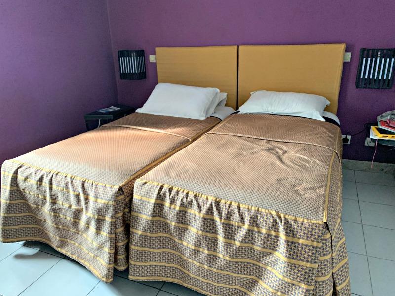 main bedroom with double beds and purple walls at El Pueblo Tamlelt hotel agadir