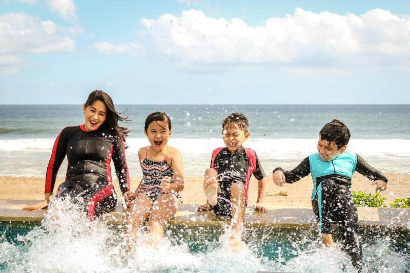 4 children splashing in the water on a UK beach