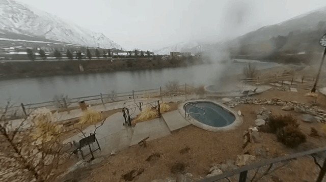 view of Iron Mountain Hot Springs and pool in front of snow covered mountains 