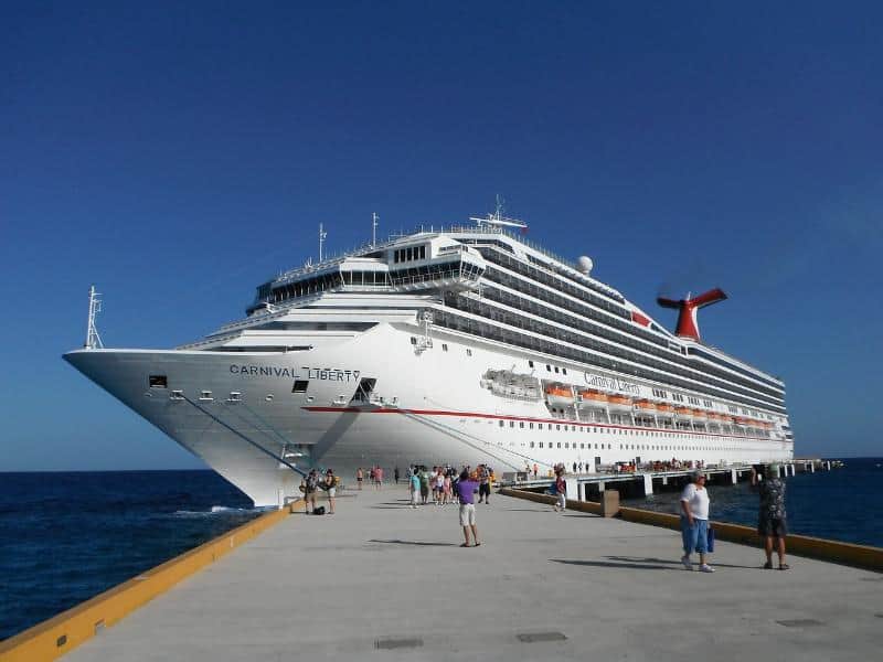 cruise ship in port with passengers walking towards it for first day of cruise