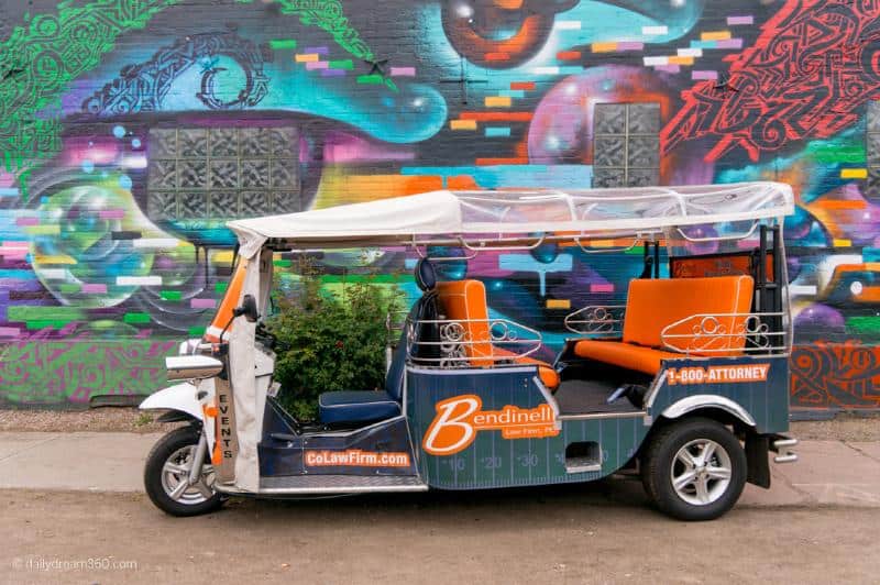 eTuk cart by street art in Denver 