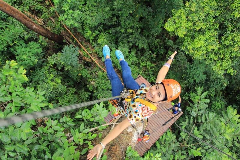 girl zip lining through trees in wales