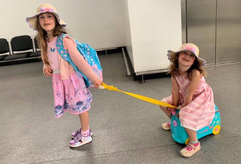 child pulling sister on trunki ride on suitcase