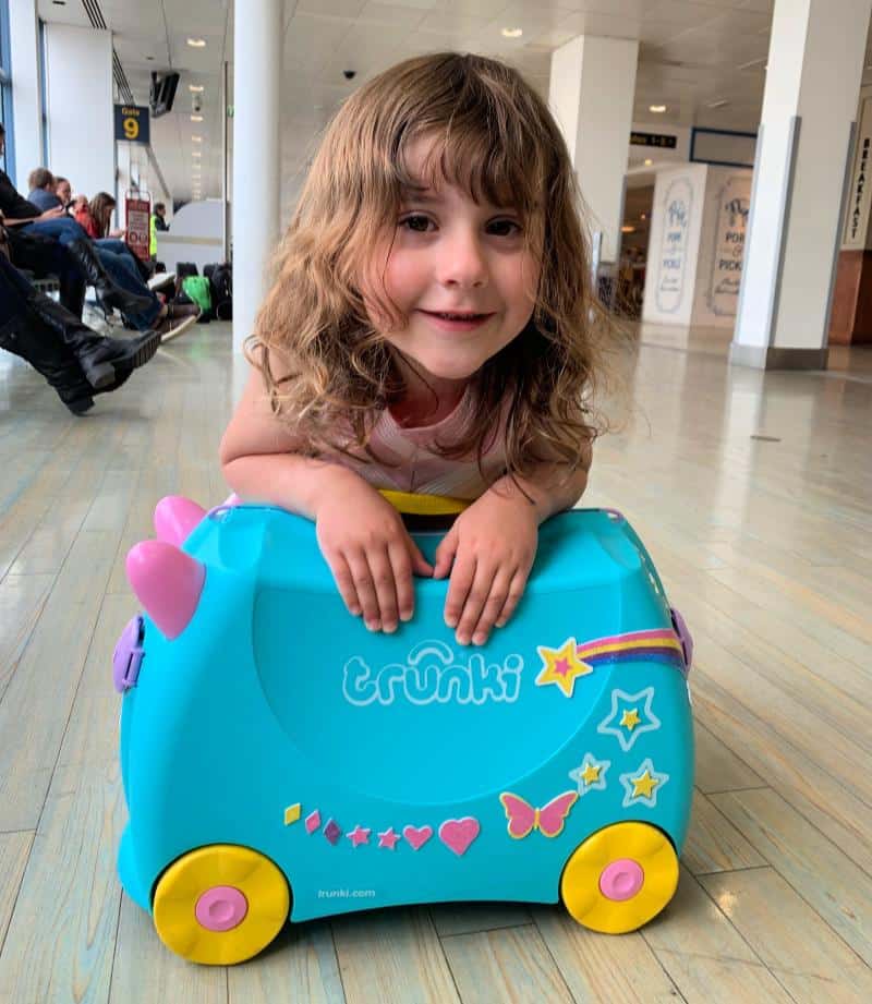 child with una the unicorn trunki suitcase