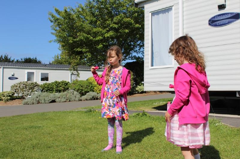 children playing outside caravan at hendra holiday park