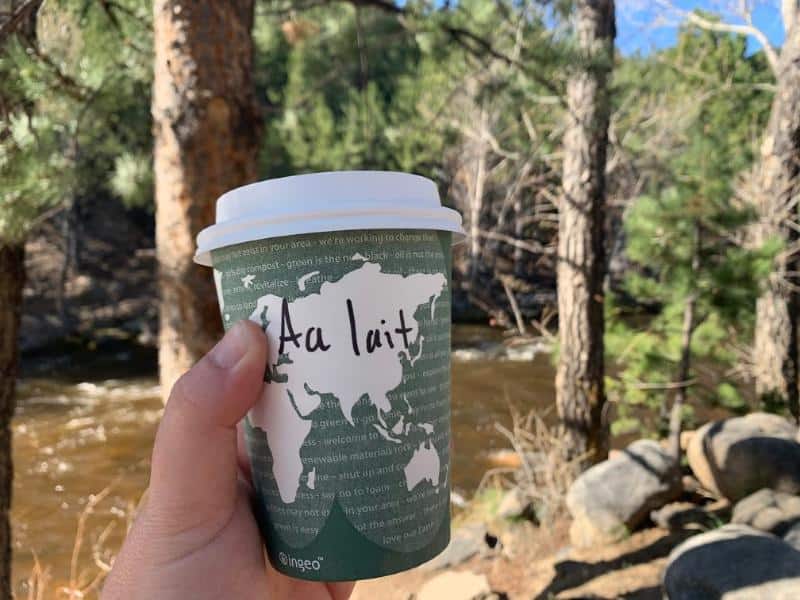 holding coffee in front of fall river estes park