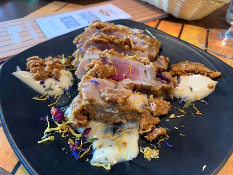 fresh tuna dish decorated with sauce and flowers