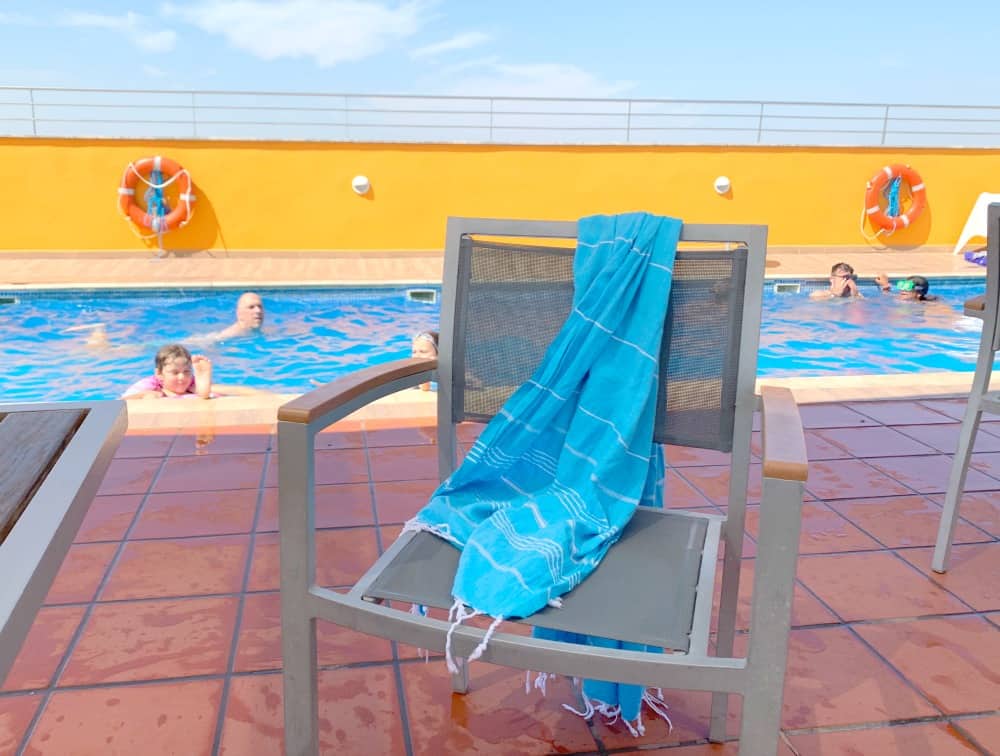sorbet hamman towel draped on chair next to pool