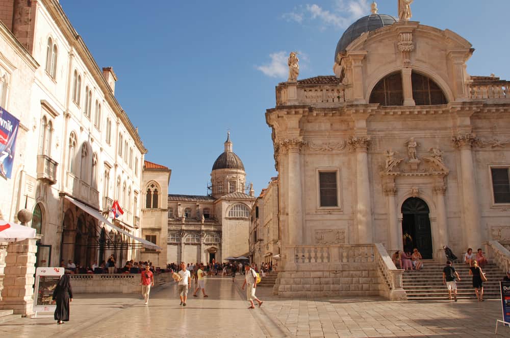 Dubrovnik, Croatia - Jule 20, 2011 : Tourists walk along on Luza Square with the Church of St Blaise in the old city of Dubrovnik,Croatia. The Church of St. Blaise is an 18th-century baroque church dedicated to the patron saint and protector of Dubrovnik.