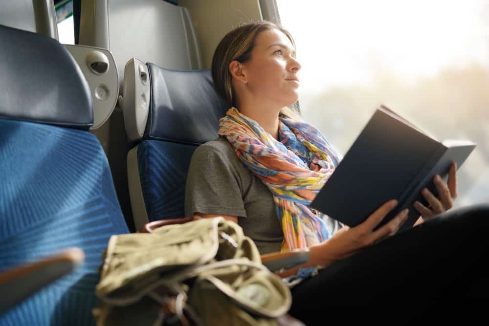 Relaxed young woman reading on the train